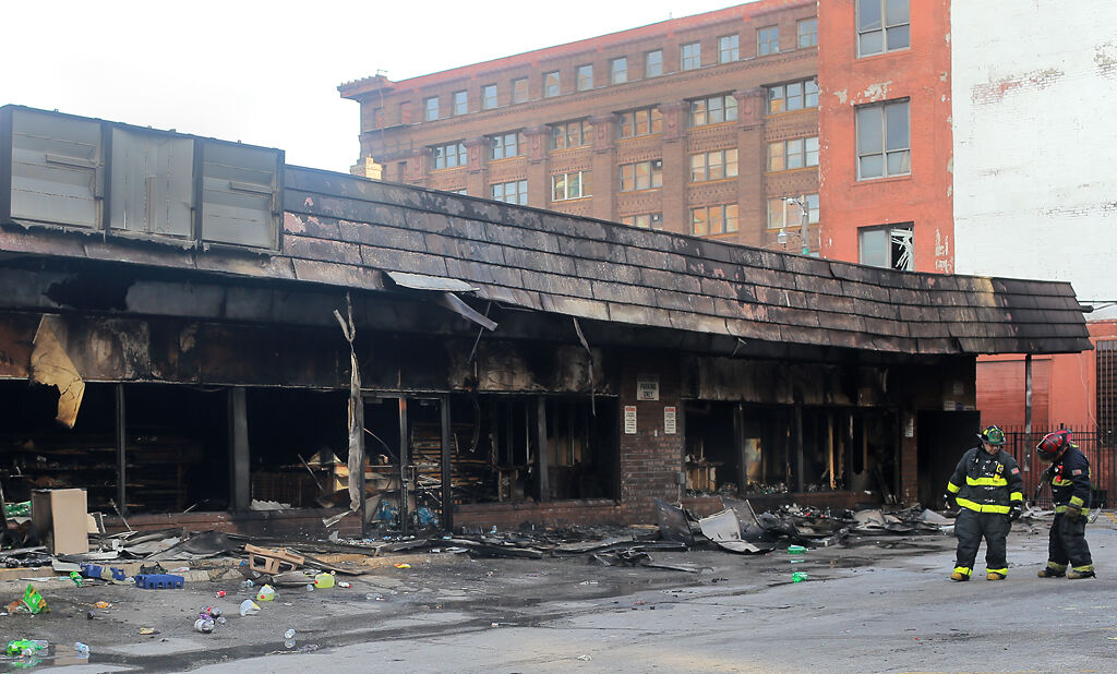 St. Louis firefighters stand in the parking lot of a 7-Eleven convenience store